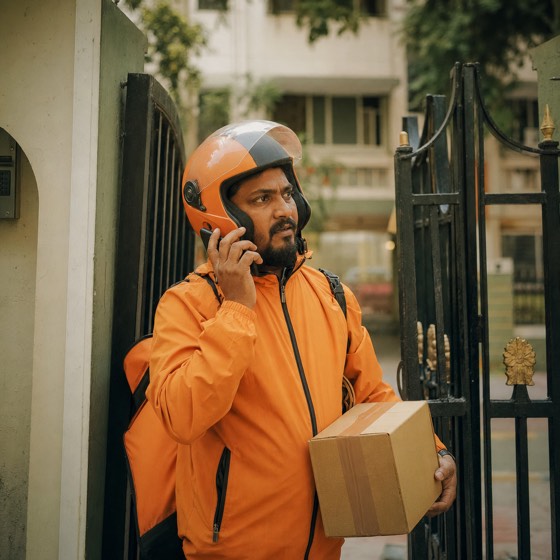 A delivery rider at an apartment gate