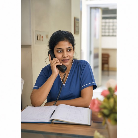 A clinic receptionist at a front desk